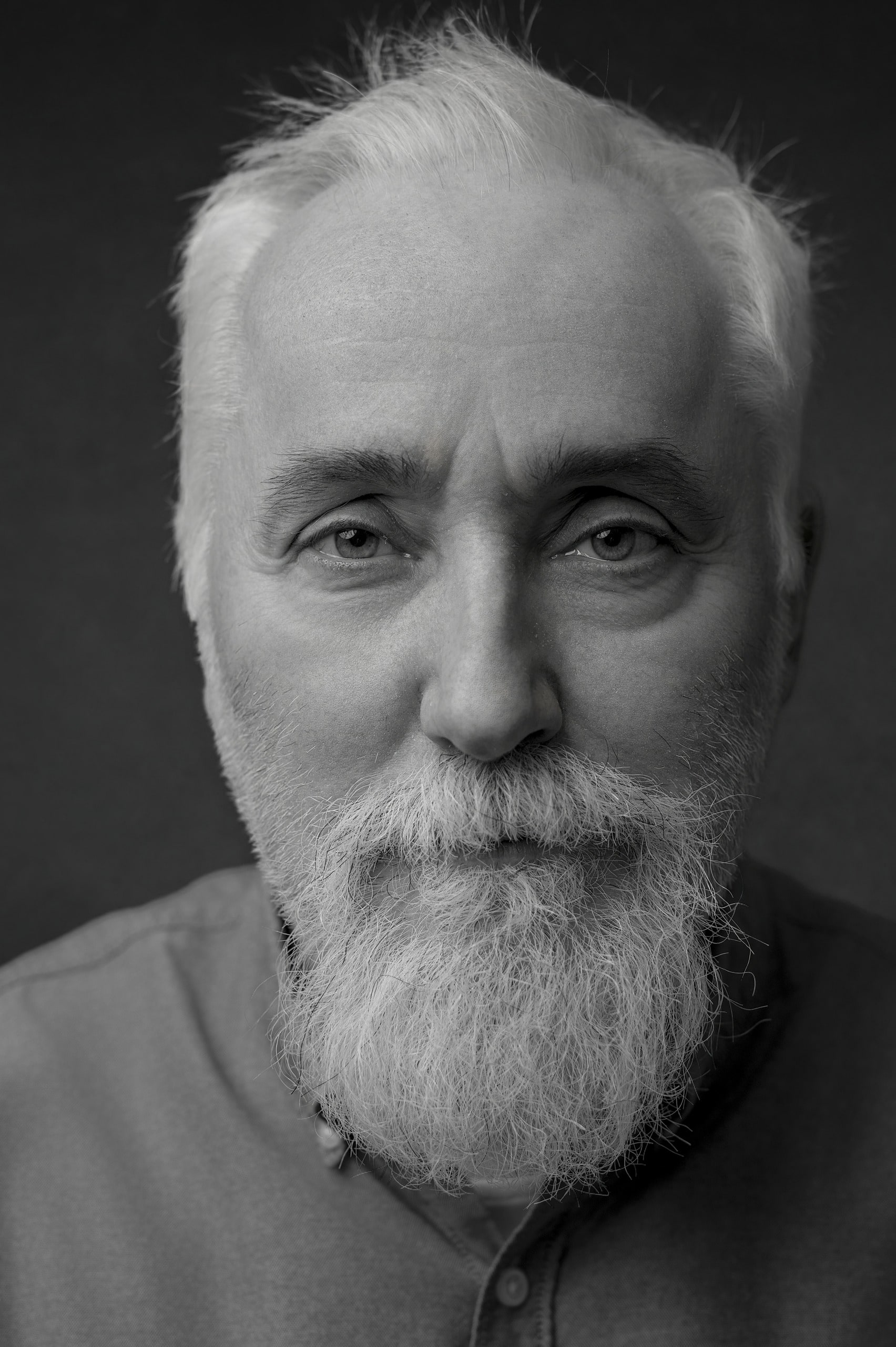 Retrato de estudio de un hombre mayor de barba blanca, en blanco y negro