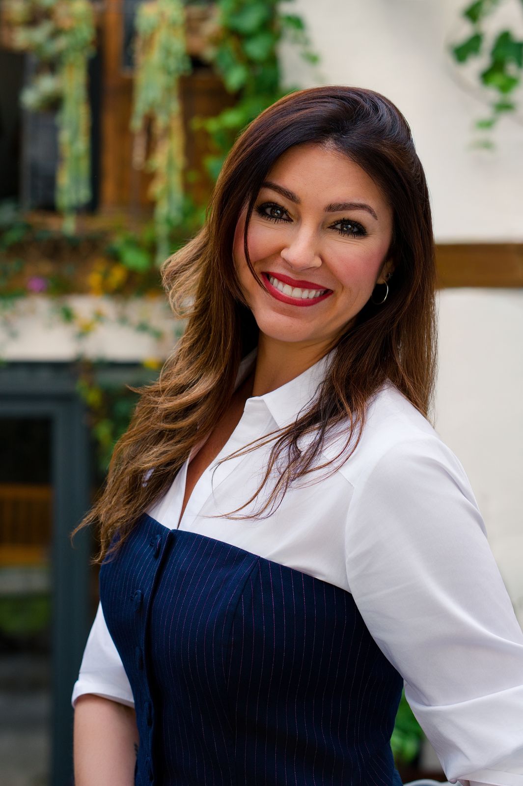 Retrato de marca de una mujer con camisa blanca y vestido azul marino