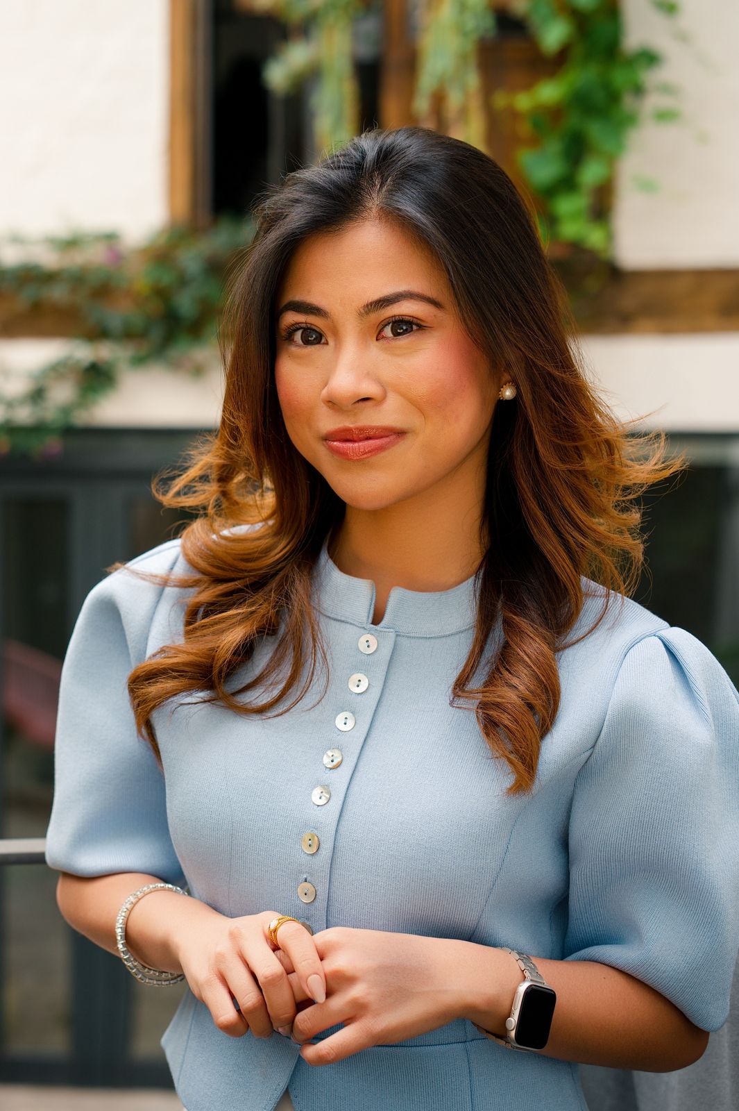Retrato de marca de una mujer con vestido azul claro, en un patio