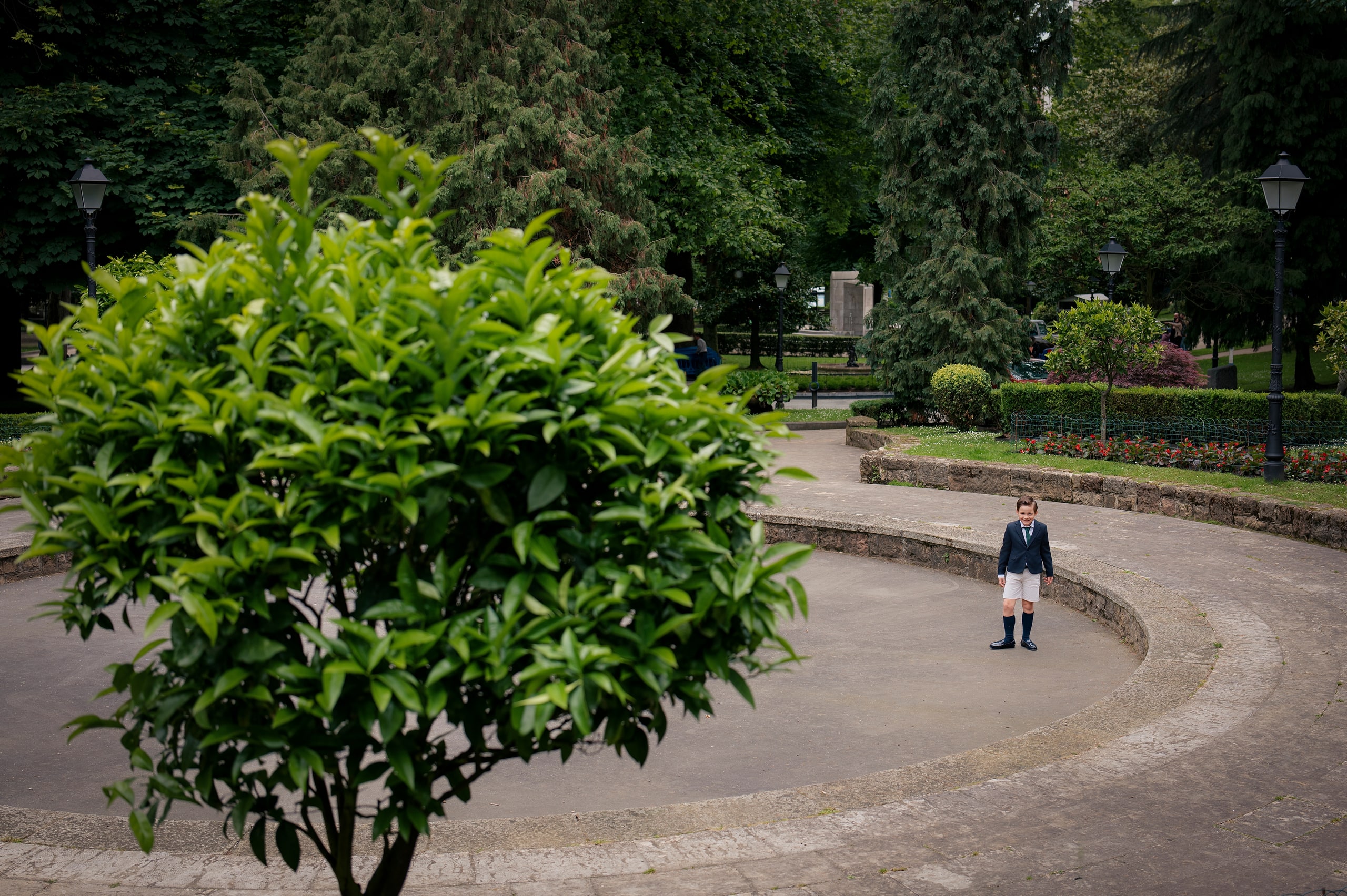 Un niño, pequeño, solo en la terraza curva de un parque