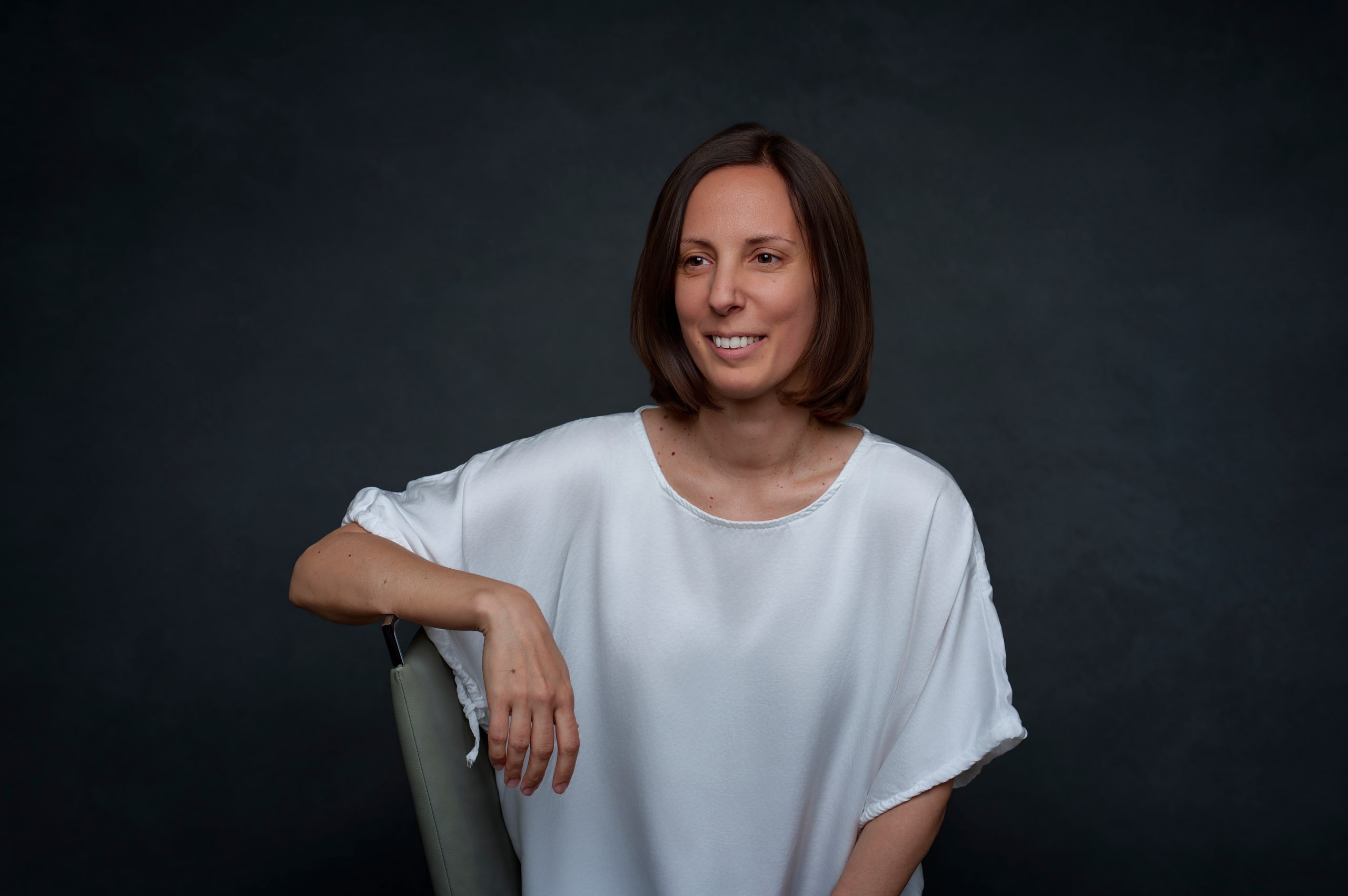 Szilvia, apoyada, con blusa blanca